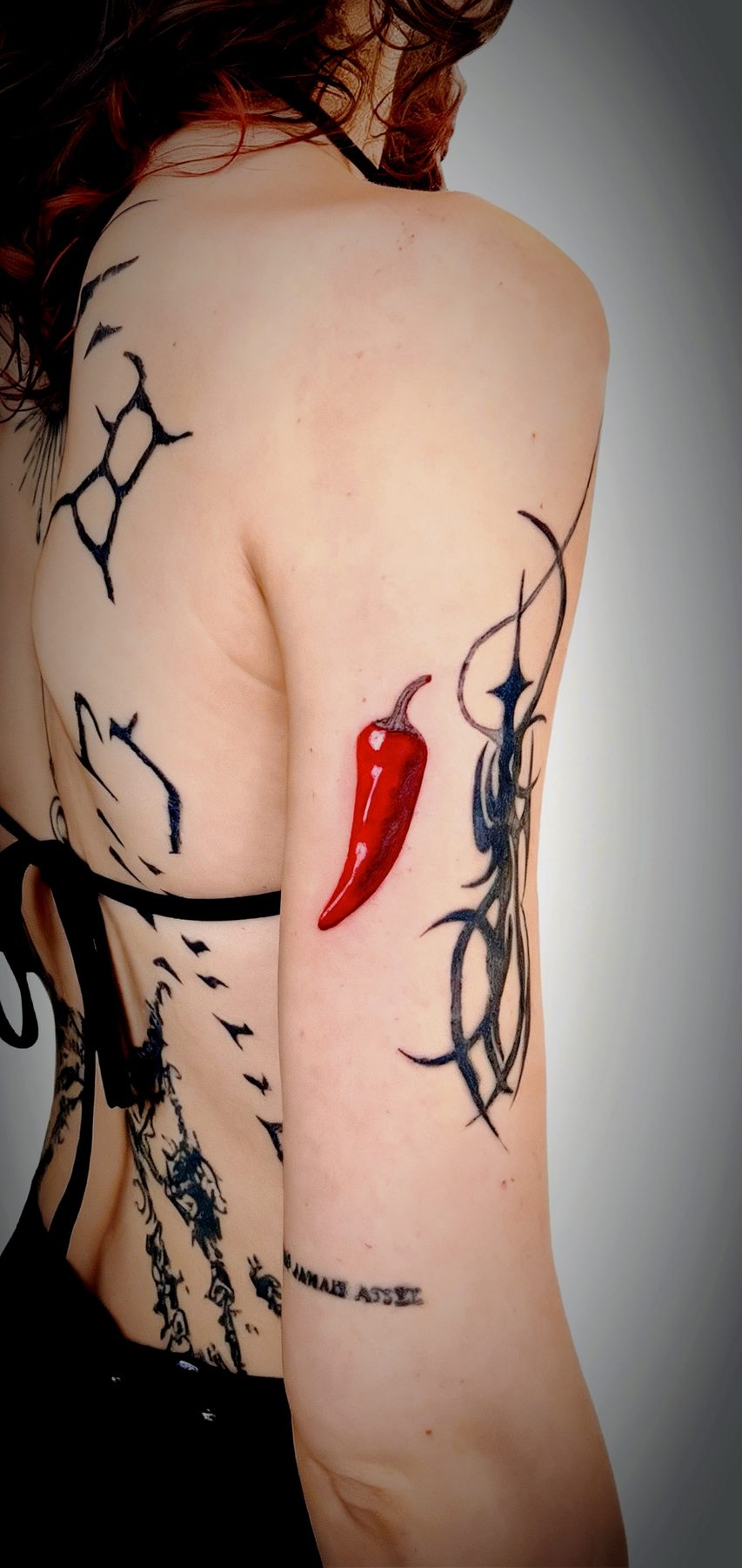 Color red chili pepper tattoo on upper arm