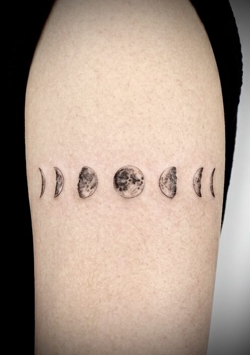 Fine line moon phases band on upper arm